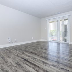 Living room with plank flooring and a sliding glass door that leads to the balcony at Stone Canyon Apartments, located in Colorado Springs, CO