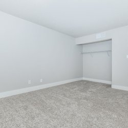 Carpeted primary bedroom with closet at Stone Canyon Apartments, located in Colorado Springs, CO