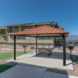 Outdoor dining area and charcoal grill covered by a pergola